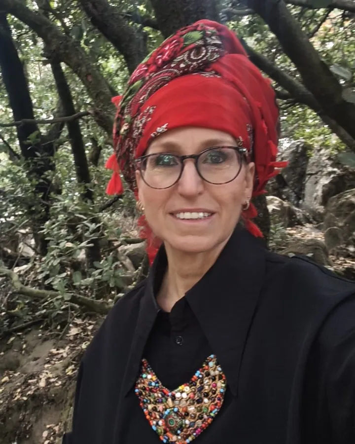 ציפה שטרן ביער, בצעיף אדום ושמלה שחורה, מחייכת